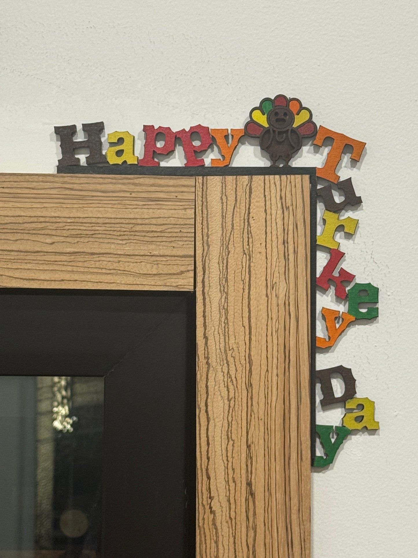 Wooden frame with colorful 'Happy Turkey Day' letters on a white background